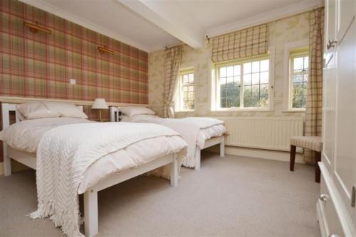 a bedroom with two beds and two windows at Holmans NEW FOREST in Burley