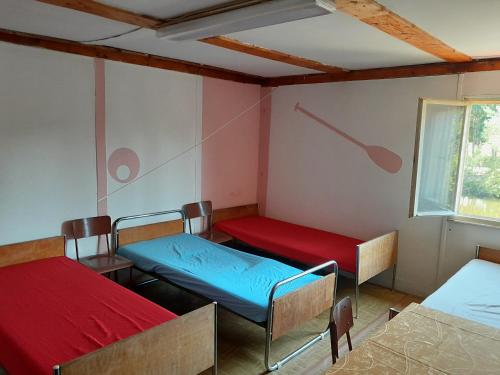 カルロヴィ・ヴァリにあるKlub vodáků Karlovy varyのベッド3台と窓が備わる客室です。