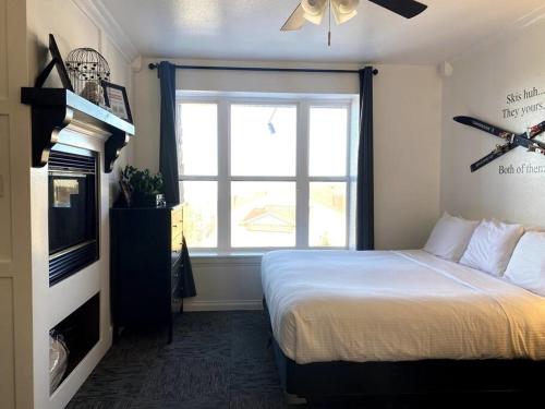 1 dormitorio con 1 cama, TV y ventana en King Bed Condo at Cedar Breaks Lodge, en Brian Head