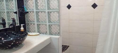 a bathroom with a black sink and a shower at Little Palace BNB in Saint Georgeʼs