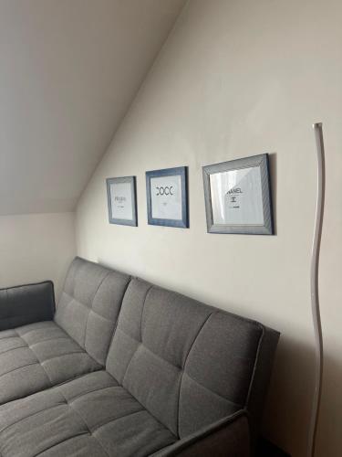 a living room with a couch and three pictures on the wall at Troisieme du nom in Nevers