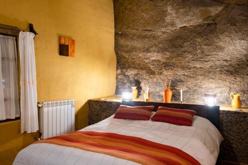 een slaapkamer met een bed met kaarsen erop bij Hotel Mallku Cueva 