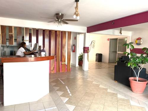 a woman sitting at a bar in a lobby at Hotel Jar8 Boca -Cerca WTC y plazas comerciales- in Veracruz