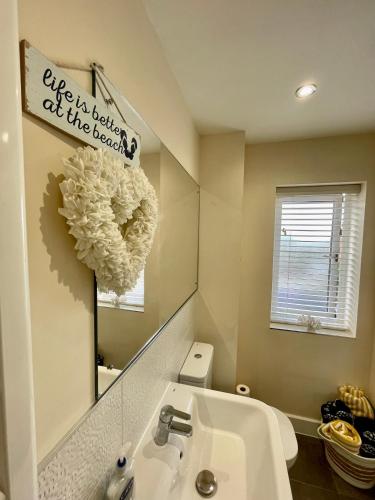 a bathroom with a sink and a mirror at Luxurious Beach House with spectacular sea views in Felixstowe