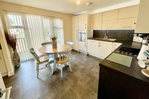 a kitchen and dining room with a table and chairs at Luxurious Beach House with spectacular sea views in Felixstowe