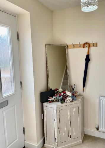 a mirror and a dresser with flowers on it at Luxurious Beach House with spectacular sea views in Felixstowe