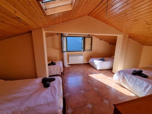 an attic room with three beds and a window at Casa Satya 