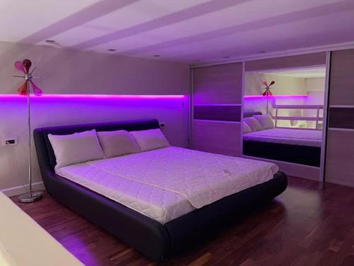 um quarto com luzes roxas nas paredes e uma cama em CITY CENTER DUPLEX em Belgrado