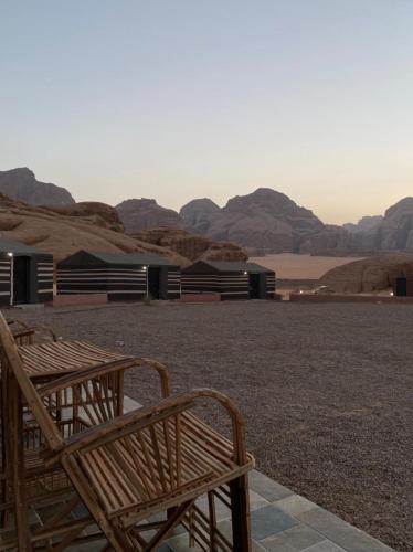 a couple of wooden benches sitting on top of a field at Bronze Mountains Camp Wadi Rum in Aqaba