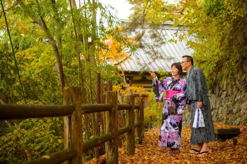 two people in kimonos walking through a garden at Sakaeya in Yamanouchi