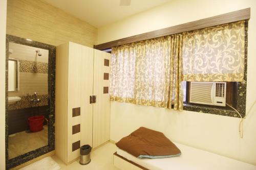 a bathroom with a sink and a window with a microwave at Hotel Al Moazin in Mumbai