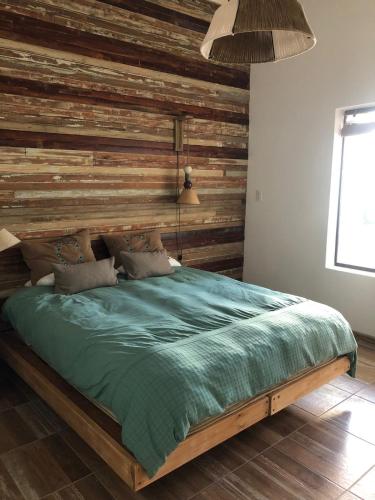 1 dormitorio con 1 cama con pared de madera en Azul en Lavalle 3 en Azul