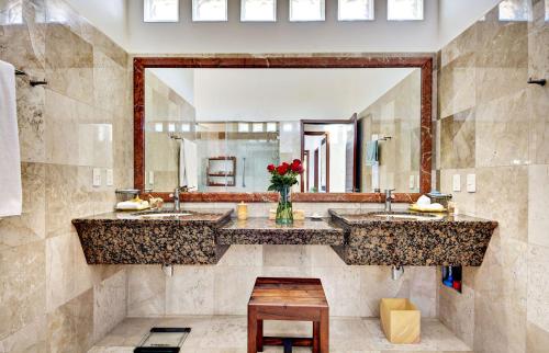 a bathroom with two sinks and a large mirror at Casa Jaguar in Puerto Aventuras