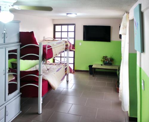 Texcoco de MoraにあるHermoso Departamento en Texcoco centro con wifi cocinaの二段ベッドと薄型テレビが備わる客室です。