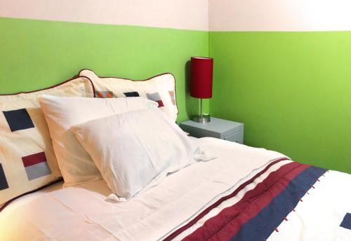 a bedroom with green walls and a bed with a red lamp at Céntrico loft Boho chic con terraza, Wifi, cocina in Texcoco de Mora