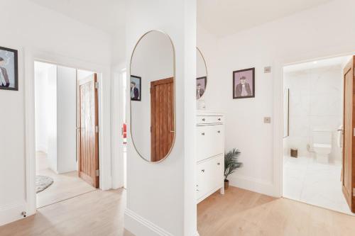 a white bathroom with a mirror and a sink at Luxury Two Bedroom Apartment in Marylebone - Central London in London