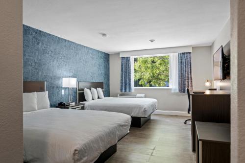 Habitación de hotel con 2 camas y ventana en Inn On Arsenal, en Watertown