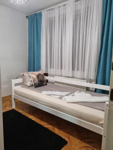 Cama blanca en habitación con ventana en Villa "Hipnotic", en Sarajevo