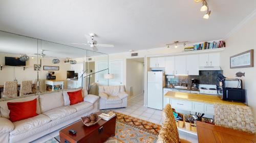 a living room with a couch and a kitchen at Beachfront at the Apollo Where the Famous Sunsets Never Get Old! in Marco Island