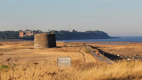 a person walking on a field next to the water at Luxurious Beach House with spectacular sea views in Felixstowe