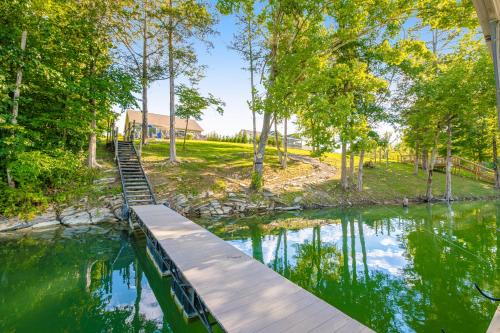 a wooden bridge over a river with trees at Norris Lake Escape in Maynardville