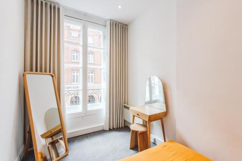 een slaapkamer met een kaptafel en een spiegel bij 2 Bedroom Apartment right on Trafalgar Square in Londen