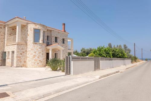 a house with a fence on the side of a road at Rafaella Beach Villa- Pvt Pool-Near Sea/Beach in Argaka