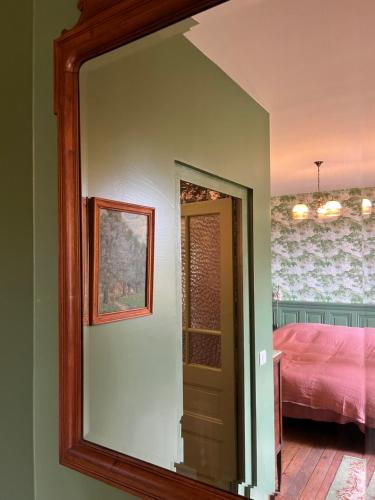 a mirror in a room with a bed and a bedroom at Le Clos Chalmon Chambre d'hôte in Montignac