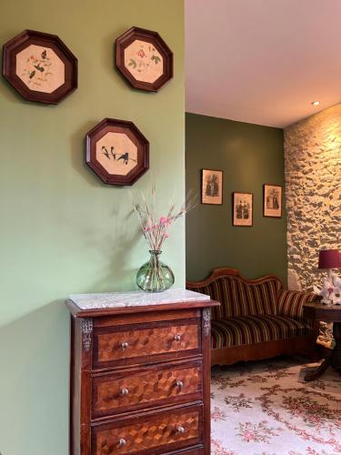 a living room with a vase on a dresser and a couch at Le Clos Chalmon Chambre d'hôte in Montignac