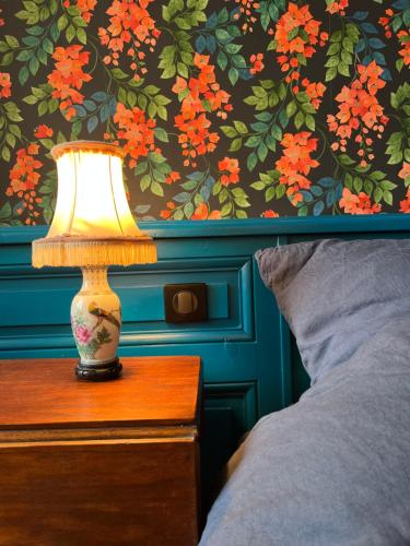 a lamp sitting on a table next to a bed at Le Clos Chalmon Chambre d'hôte in Montignac