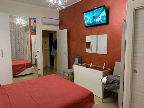 a bedroom with two beds and a television on the wall at Luxury House Gioiosa in Gioiosa Marea