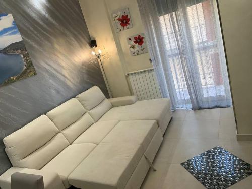 a living room with a white couch and a window at Luxury House Gioiosa in Gioiosa Marea