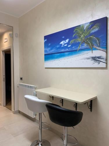 a white desk with a palm tree on a wall at Luxury House Gioiosa in Gioiosa Marea