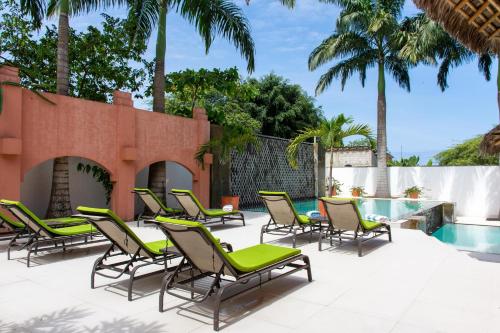 een patio met ligstoelen en een zwembad bij New Nautilus Lodge in Puerto López