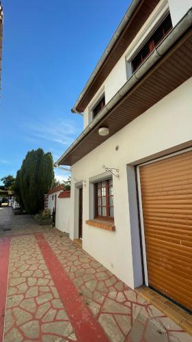 un bâtiment avec une porte de garage sur son côté dans l'établissement Le Hâble 2 Paix - gîte rural en Baie de Somme, à Woignarue
