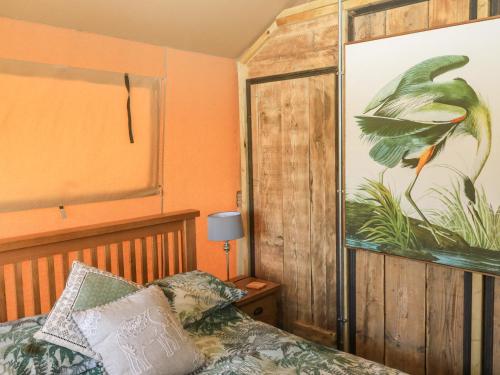 um quarto com uma cama e uma grande pintura na parede em Semira Tent Lodge em Totnes