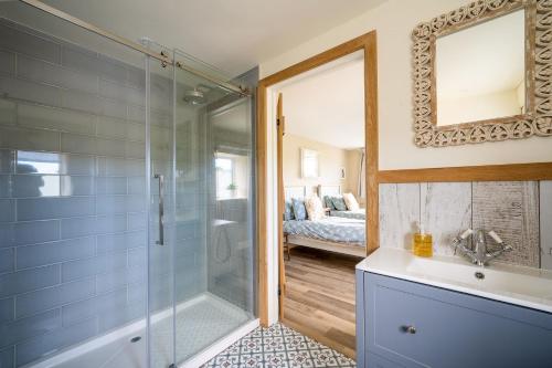 a bathroom with a shower and a sink and a mirror at Daydreamer Cottage in Padstow