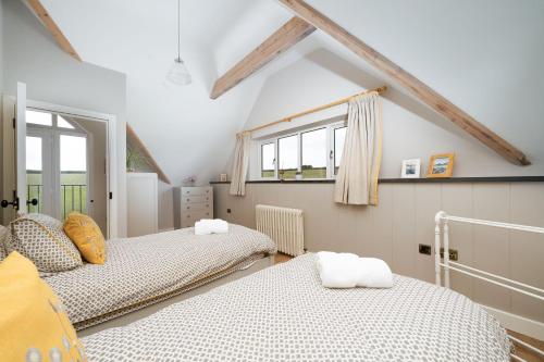a attic room with two beds and two windows at Daydreamer Cottage in Padstow