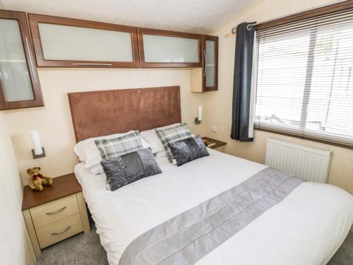 um quarto com uma cama grande e uma janela em Poppy Lodge em Stratford-upon-Avon