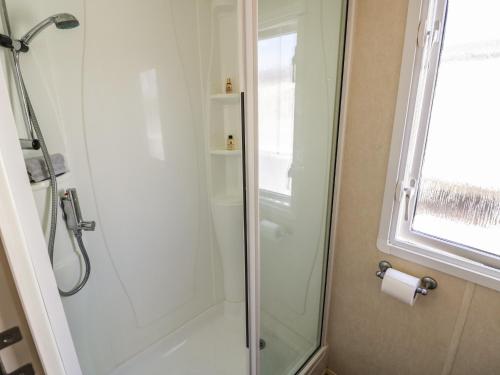 a shower with a glass door in a bathroom at Poppy Lodge in Stratford-upon-Avon