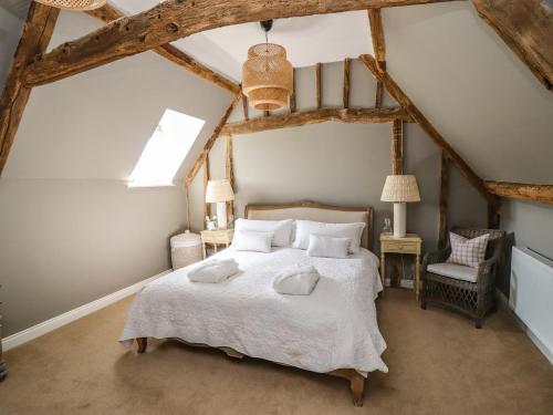una camera da letto con un grande letto in mansarda di The Compton Cottage a Cheltenham