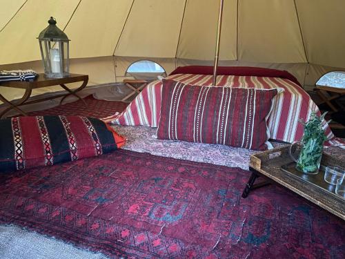 Camera con letto e cuscini in tenda. di Suxen nature experience - glamping con vista panoramica a Prepotto