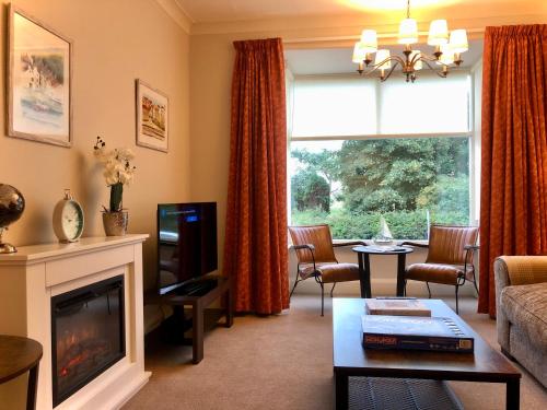 een woonkamer met een bank en een open haard bij White Gable in Scarborough