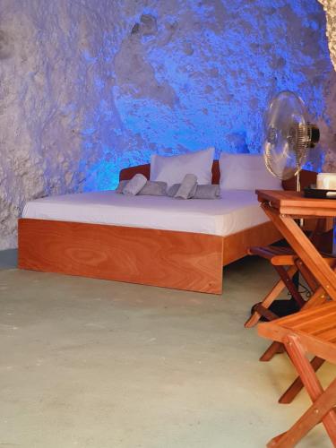 Bett in einem Zimmer mit blauer Wand in der Unterkunft Anassa Cave by Estia in Iraklio
