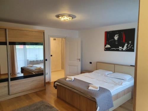 una camera con un grande letto e uno specchio di Apartament Luxury a Vişeu de Sus