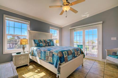 a bedroom with a bed and windows and a ceiling fan at Gulf Sunset View on Deep Water Canal minutes from Weeki Wachee Springs in Hernando Beach