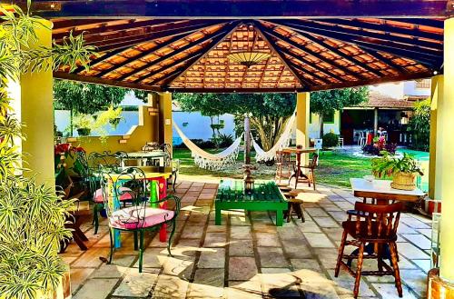 a patio with tables and chairs under a pergola at Pousada Chez Moi in Cabo Frio
