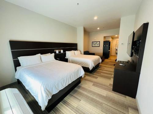 a hotel room with two beds and a flat screen tv at Holiday Inn Express & Suites Salinas by IHG in Salinas