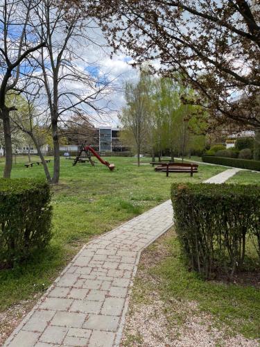 einen Park mit einem Ziegelweg und einem Spielplatz in der Unterkunft Leila Apartman in Balatonfüred