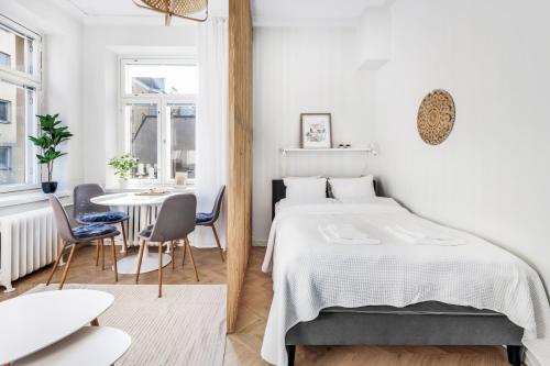 a bedroom with a bed and a table and chairs at WeHost Nordic Glamour nearby the Tervasaari Island in Helsinki